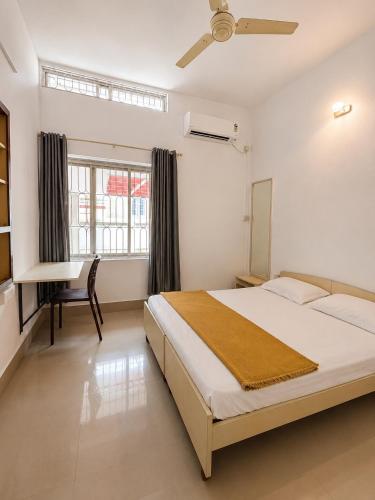 a bedroom with a bed and a desk in it at 3bhk villa in Lalbagh in Mangalore