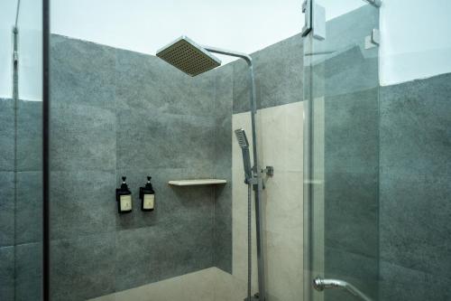 a shower with a glass door and two bottles at Wasala Banquets & Nature Resort in Radawana