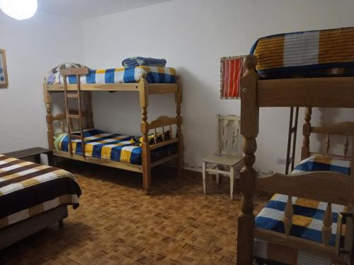 a room with three bunk beds in a room at Loma Tika - Tilcara Hostel in Tilcara