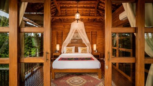 a bedroom with a bed in a wooden house at Nan Seasons Boutique Resort in Nan