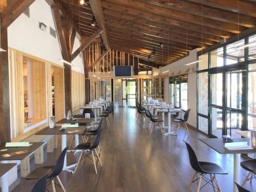 a dining room with tables and chairs and windows at Mirasierra in Santo Tomé del Puerto