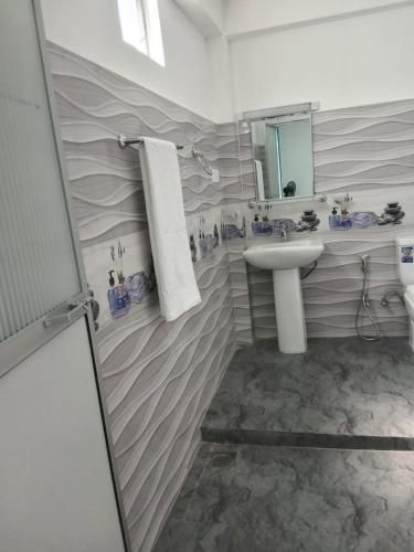 a bathroom with a sink and a mirror at NIVRA Homestay in Kumbalwela