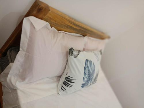 a bed with two white pillows and a wooden headboard at TDGuestRoom Siargao in Dapa