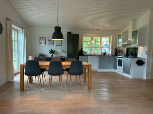 a dining room table and chairs in a kitchen at Lovely Cottage With Secluded Garden in Rødby