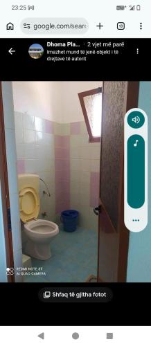 a bathroom with a toilet and a phone on the door at Vila Gega in Tale
