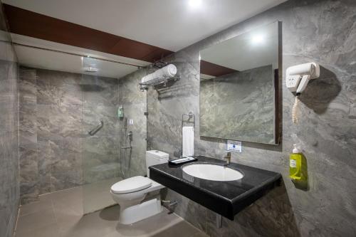 a bathroom with a toilet and a sink and a shower at TSG Emerald View Hotel and SPA in Port Blair