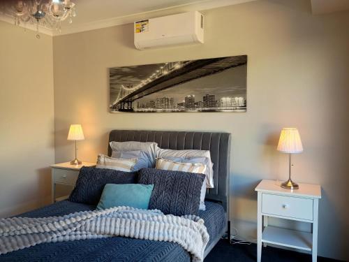 a bedroom with a bed and a picture of a bridge at Eden beach retreat in Jindalee