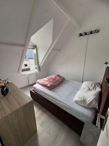 a small bedroom with a bed and a window at Mamounette in Sarzeau