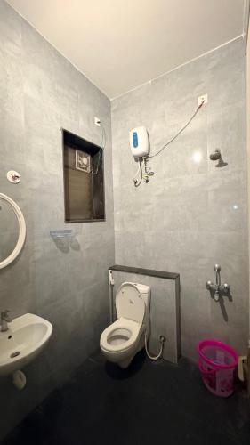a bathroom with a toilet and a sink at VVR villa in Tirupporūr