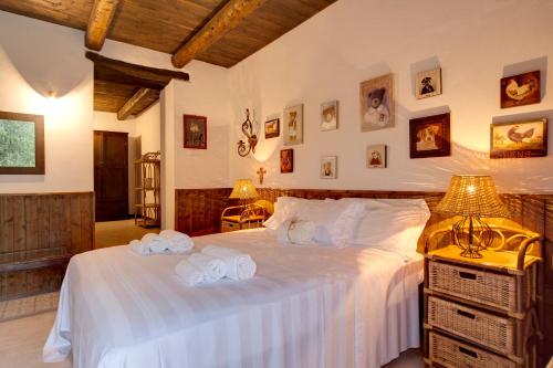a bedroom with a large bed with towels on it at Riserva Privata San Settimio in Arcevia
