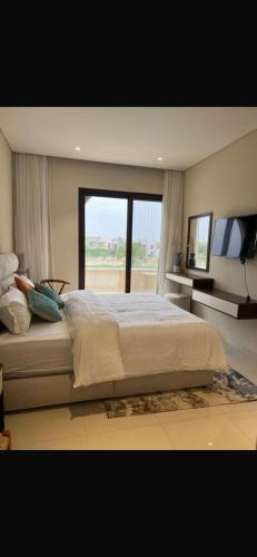 a bedroom with a large bed with a large window at Zill Hawana in Ma‘mūrah