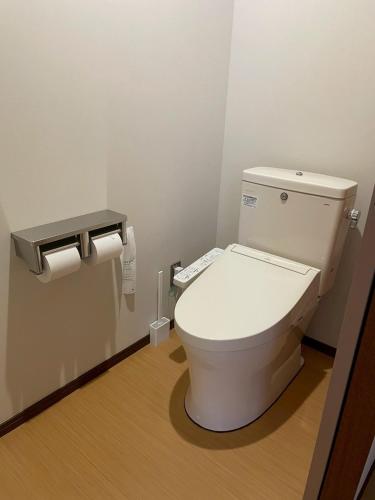 a bathroom with a toilet with two rolls of toilet paper at あらとんとんの宿 in Setouchi
