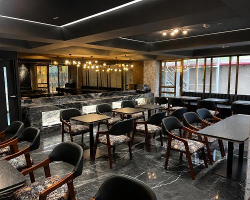 a restaurant with tables and chairs and a bar at Hotel Aston Residency in Kolkata
