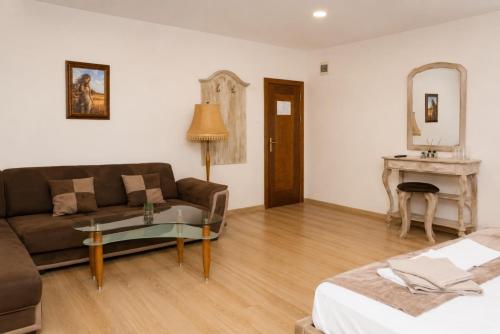 a living room with a couch and a table at Хотел Терес in Kazanlŭk