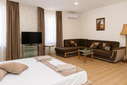 a hotel room with a bed and a couch at Хотел Терес in Kazanlŭk