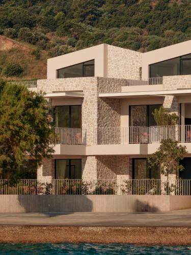 an apartment building with a hill in the background at Petra Mare Villas in Psathopyrgos