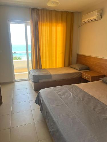a hotel room with two beds and a large window at Mavi Cennet Camping Caravan in Kızılot