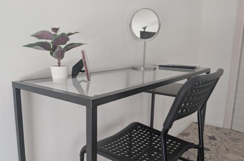 a glass desk with a chair and a mirror at Il quadrifoglio in Serino