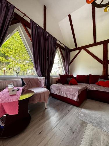 a living room with two beds and a table at Casa Din Lunca in Poiana Mărului