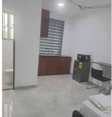 a room with a bed and a desk and a sink at Meg place in Amamoli