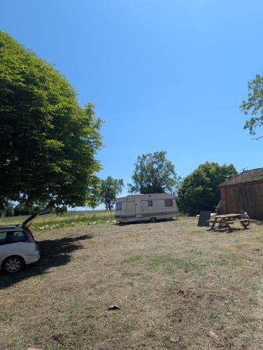 a car parked next to a trailer and a picnic table at Au soleil in Virac