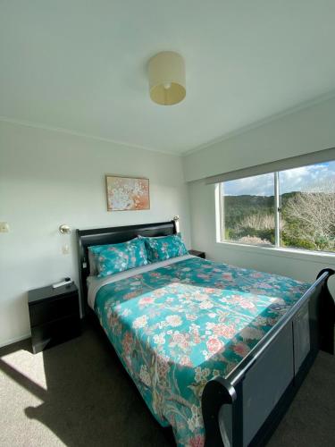 a bedroom with a bed and a window at Cable Bay Moana View House in Cable Bay