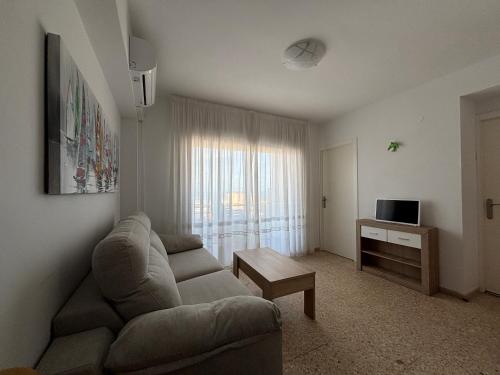 a living room with a couch and a table at NEW UDYNO in Piles