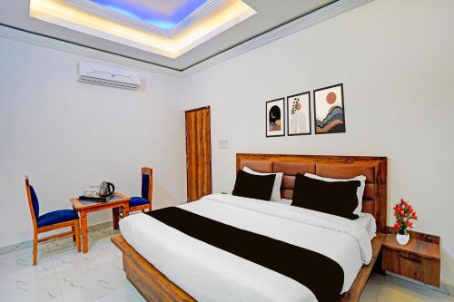 a bedroom with a bed and a table and a chair at Townhouse Vikas Nagar Lucknow Formerly Wave BLU in Lucknow