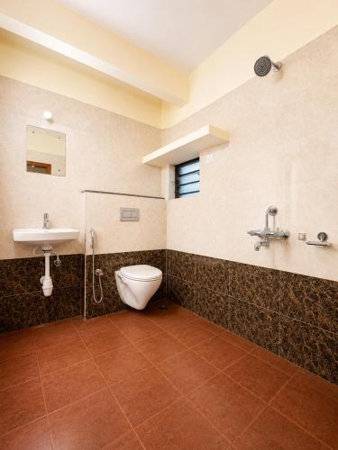 a bathroom with a toilet and a sink at SLV Comforts in Chikmagalūr