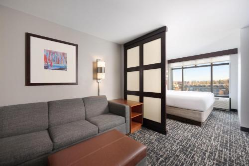 a living room with a couch and a bed at Hyatt Place Columbus/OSU in Columbus