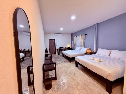 a hotel room with two beds and a mirror at Fix25House Koh Kood in Ban Khlong Mat