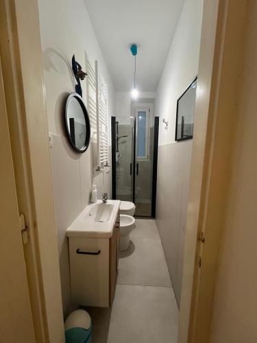 ein Badezimmer mit Waschbecken, Toilette und Spiegel in der Unterkunft Viale 76 in Triest