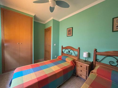 a bedroom with two beds and a ceiling fan at Voramar VI in Piles