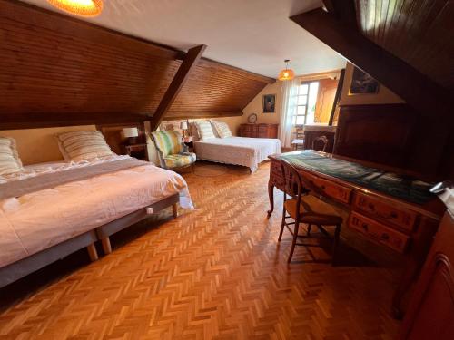 a bedroom with two beds and a desk and a table at Le Clos Colette in Neuvy
