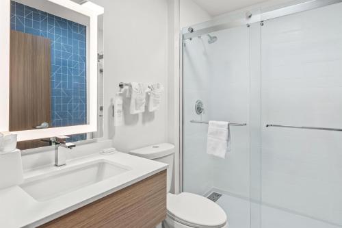 a bathroom with a sink and a toilet and a shower at Spark by Hilton Milford Boston in Milford