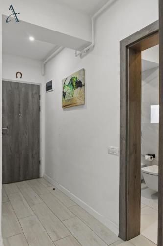 a hallway with a door and a bathroom with a toilet at Apartment in MoonLight Residence in Mamaia