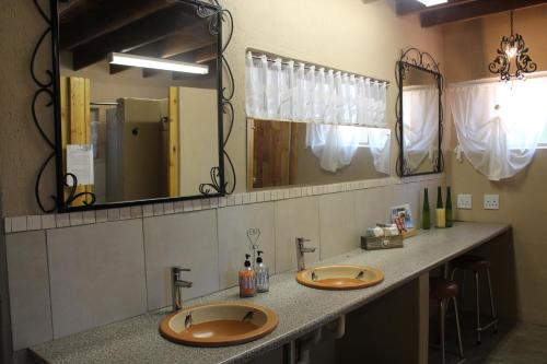 een badkamer met 2 wastafels en een grote spiegel bij Kiaat Bungalows in Hazyview