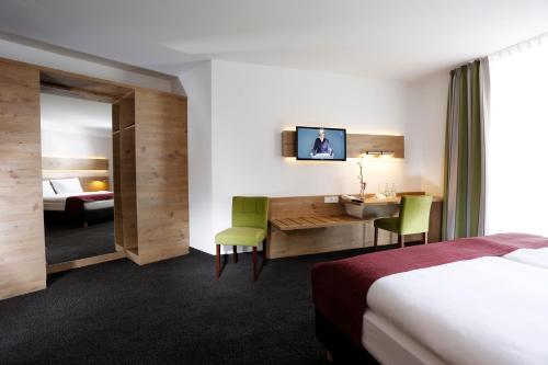 a hotel room with a desk and a bed at Hotel Sachsenross in Nörten-Hardenberg