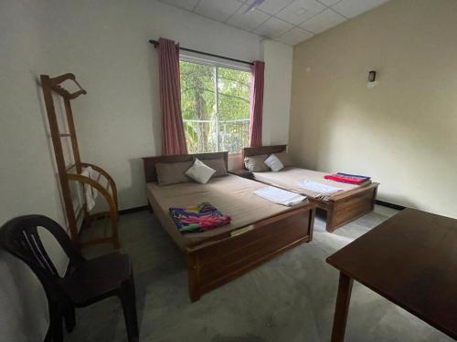 a room with a bed and a chair and a window at D&D Holyday Homes in Kandy