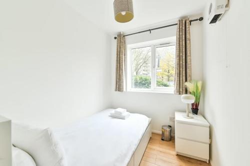 a bedroom with a white bed and a window at Paprika Nest in Hendon