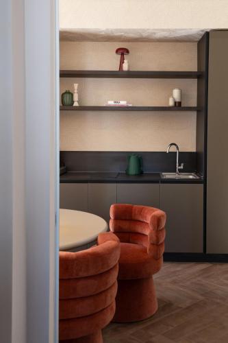 a room with a table and a chair and a sink at Fill's Luxury Design Apartments 100m from the Beach in Rimini