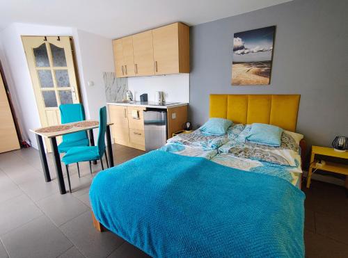 a bedroom with a bed and a table and a kitchen at Domek dla dwojga w Stegnie in Stegna