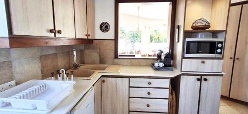 a kitchen with a sink and a microwave at Bay Rose in Pointe d'Esny