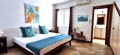 a bedroom with a large bed with blue pillows at Bay Rose in Pointe d'Esny