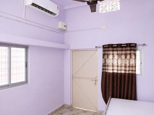 a room with a shower and a door and a window at Harshvardhan Lodge in Narsimhapur