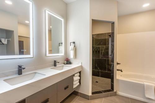 a bathroom with two sinks and a shower at The Valor, an Ascend Collection Hotel in Parowan
