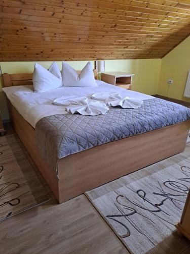 a bedroom with a large bed with a wooden ceiling at Pension Casa Maria in Sovata
