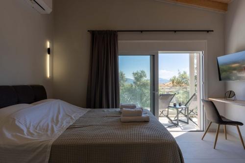 a bedroom with a bed and a television and a balcony at Aurea Ionian Villas in Apolpaina