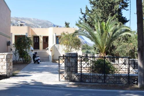 a house with a palm tree in front of it at Το περασμα in Panormos Kalymnos