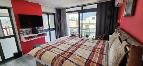 a bedroom with a bed and a large window at Kirkor Guest House in Famagusta